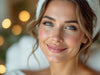 Professional woman in her 40s gently touching her under-eye area with a natural smile, demonstrating gentle self-care